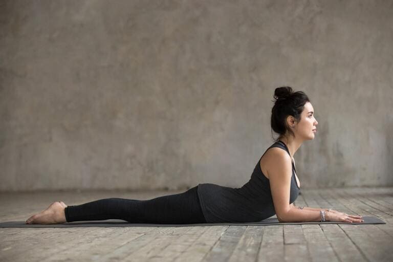 Thực hiện bài tập yoga chữa đau khớp vai tư thế nhân sư phần thân dưới áp sát xuống sàn